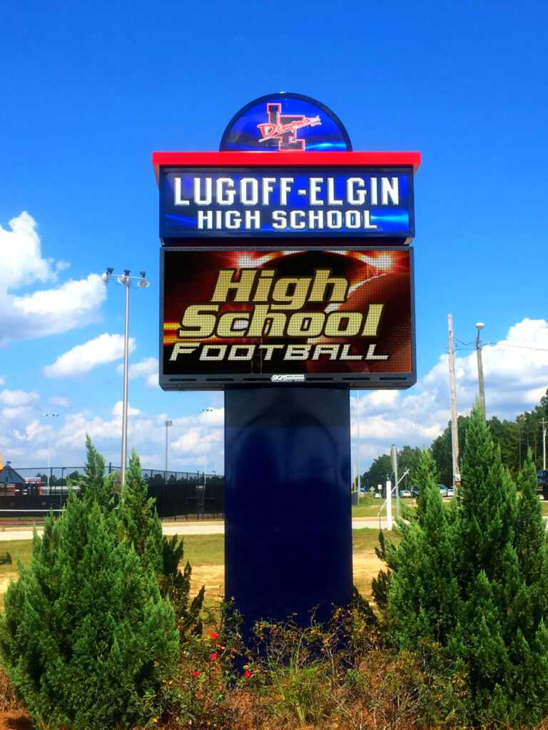 Electronic sign for Lugoff-Elgin High School displays High School Football under a blue sky.